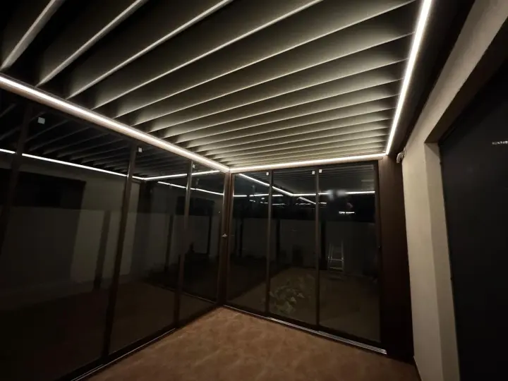 Inside the enclosed terrace at night, louvres open and LED lighting on