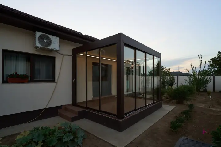 Bioclimatic pergola mounted against a single-storey house