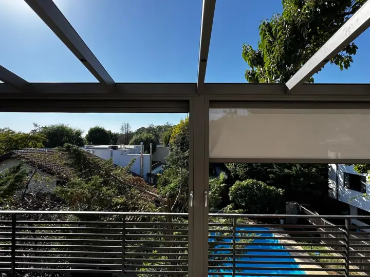 View of the garden from under the glass roof, with the zip screen raised