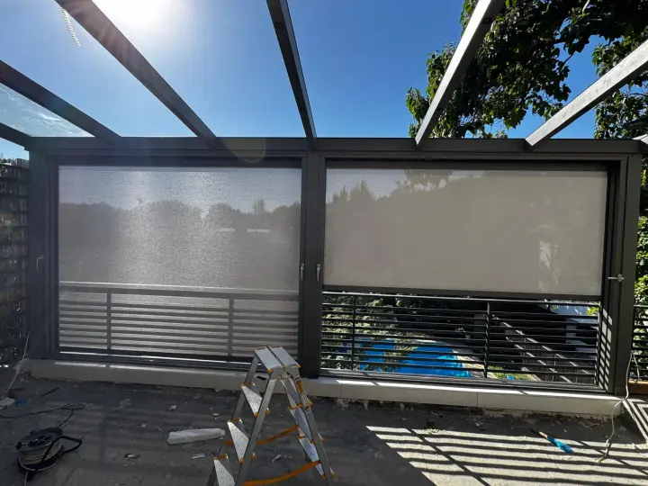 Zip screens lowered to different heights on the glass-roofed terrace